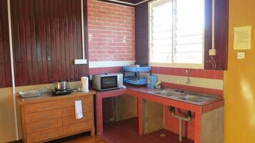 A compact kitchen with a microwave, toaster, and sink.