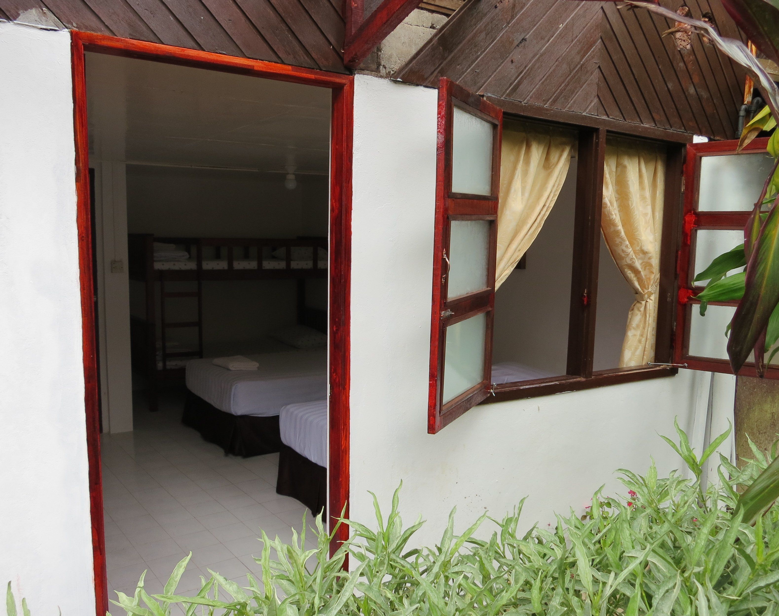 A small, single-room accommodation with a wooden roof and a white exterior.