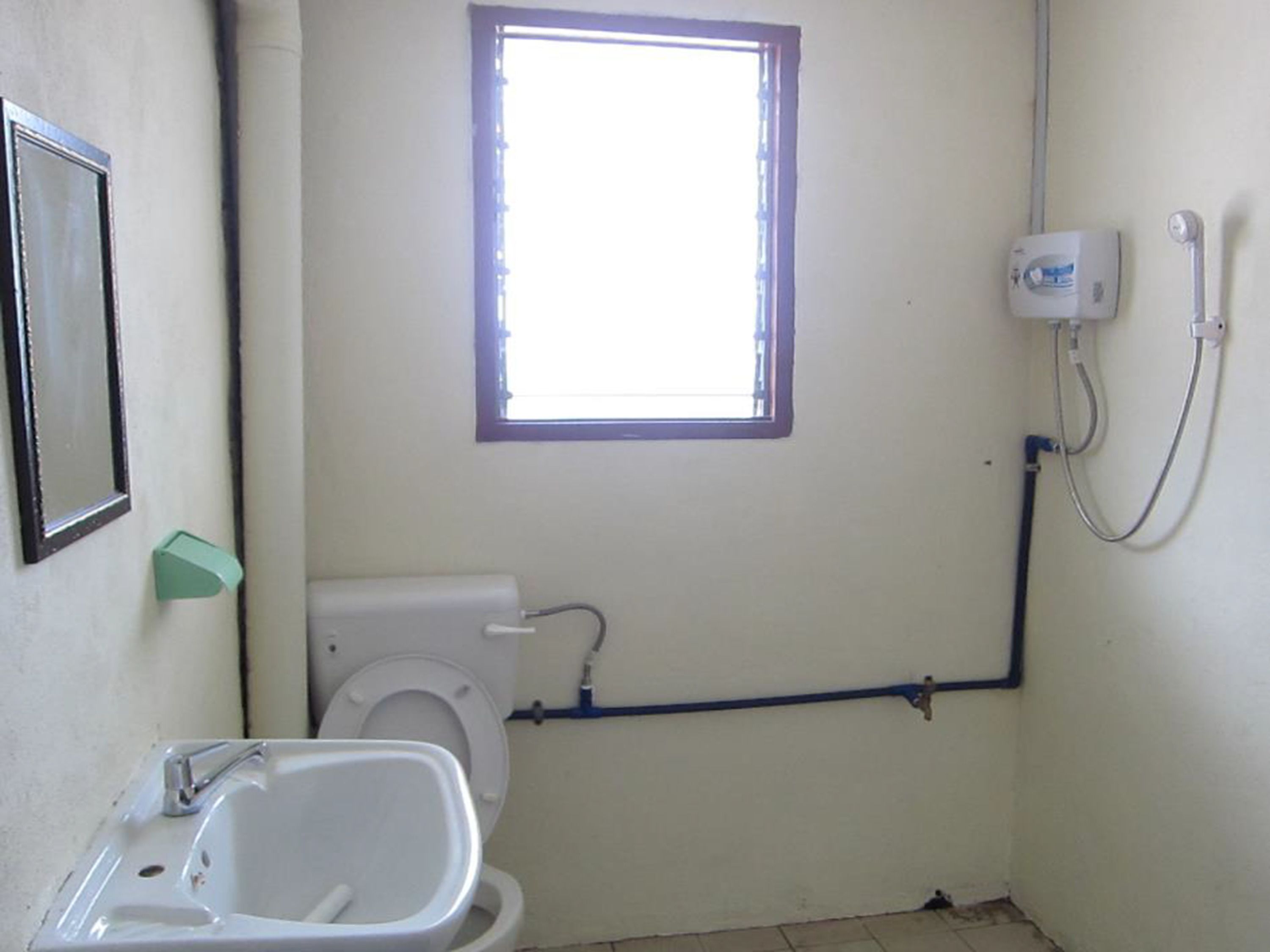 A small bathroom with a toilet, sink, and window.