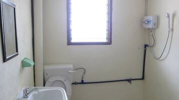 A small bathroom with a toilet, sink, and window.