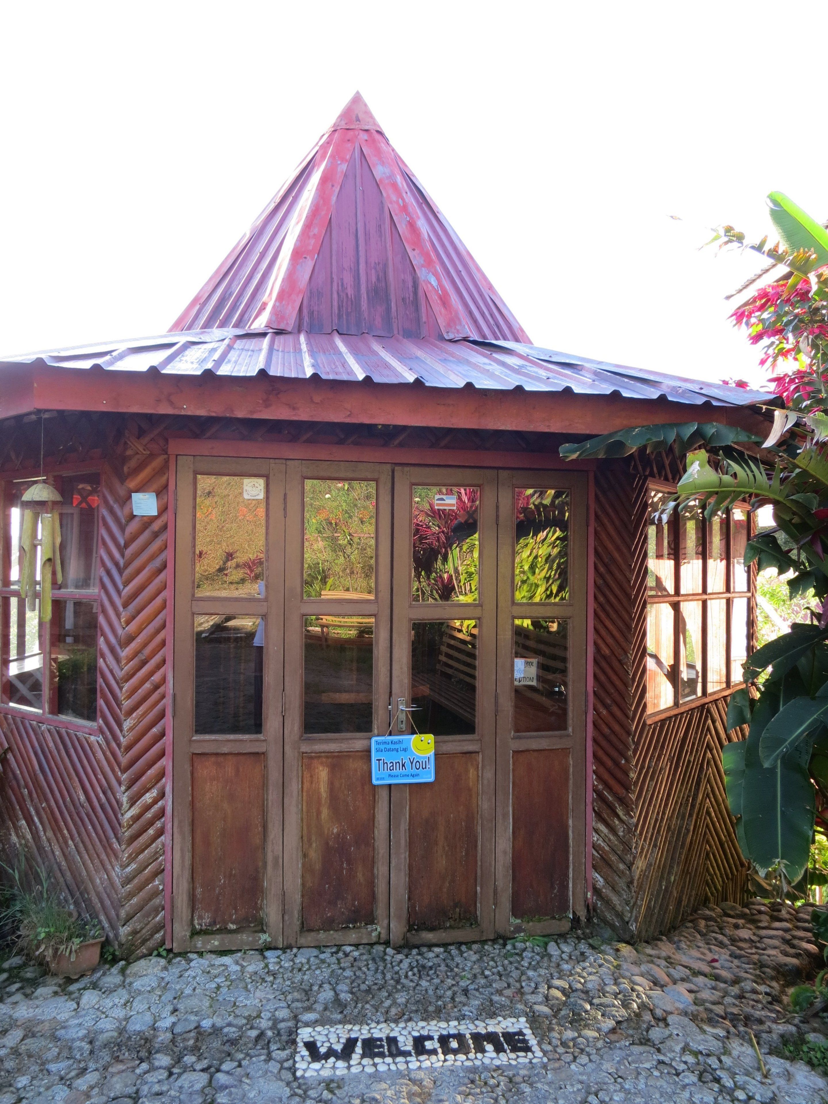 A small wooden structure with a sloped roof, a welcome mat, and a sign that says "Thank You!"