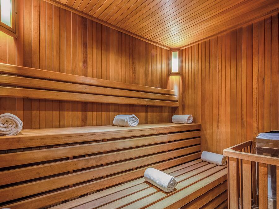 Una sauna de madera con bancos y toallas.