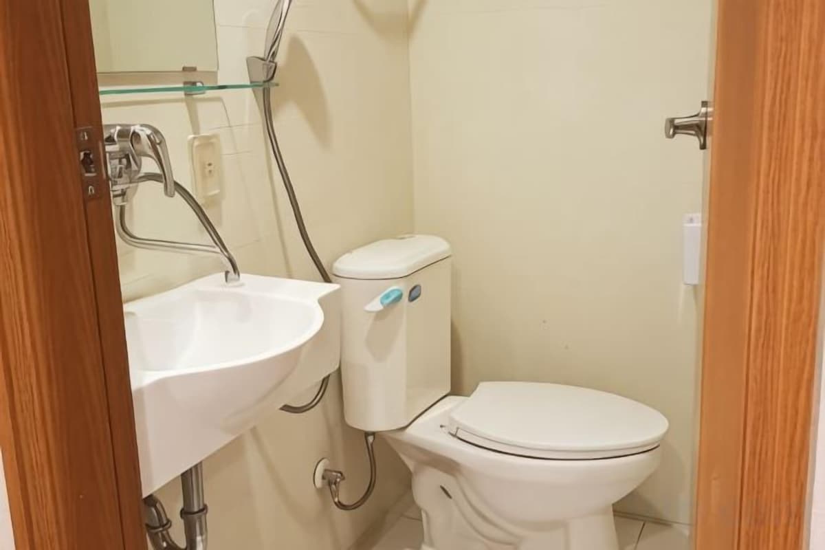 A bathroom with a white sink, toilet, and glass shower enclosure.