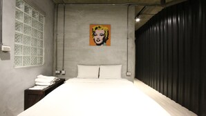 A bedroom with a bed, a window with a decorative screen, a painting on the wall, and a dark curtain. - Cheers Loft - Hostel (Taipei)