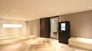 A modern hotel room with a wooden herringbone floor, a seating area with a bench, and a minibar. - Cheers Loft - Hostel (Taipei)