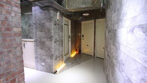 A hallway with a tiled floor, a brick wall, and two doors. - Cheers Loft - Hostel (Taipei)
