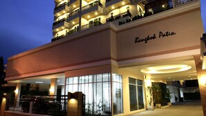 Een meerlaags hotel met balkons en een bord waarop 'Bangkok Patia' staat.
