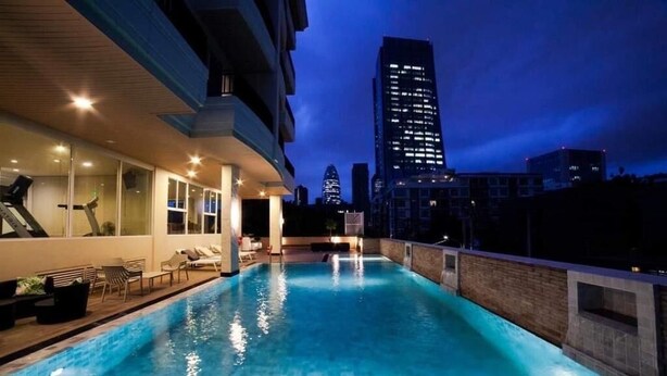 Zwembad met stadsgezicht, een fitnessruimte en een lounge met terras.
