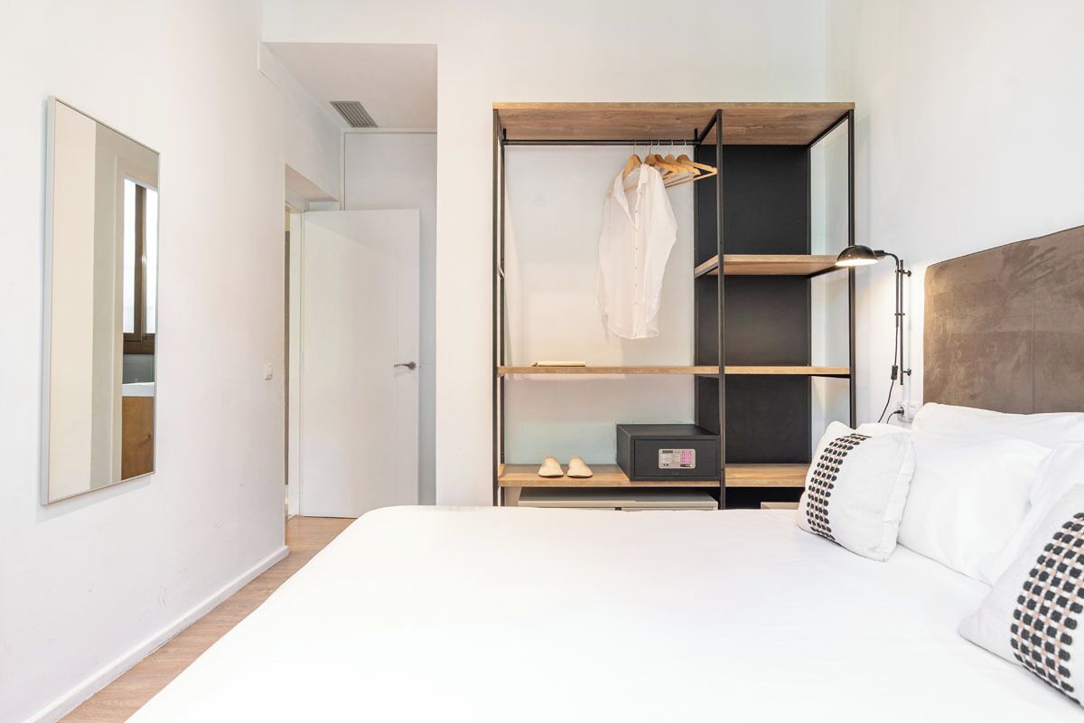 A bedroom with a bed, a wardrobe, and a bedside table.