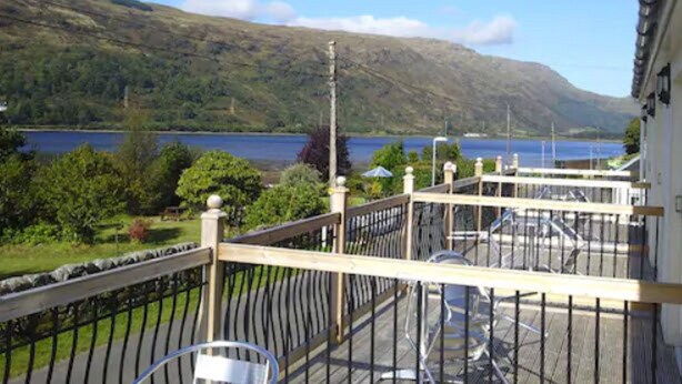 A balcony with a view of a lake and mountains. - Cairndow Stagecoach Inn (Cairndow)
