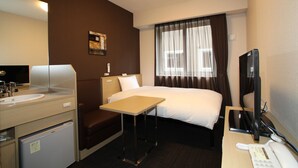 A hotel room with a bed, a desk, a chair, a small table, a desk lamp, a television, and a refrigerator. - HOTEL ROUTE-INN Kesennuma ChuoInter (Kesennuma)