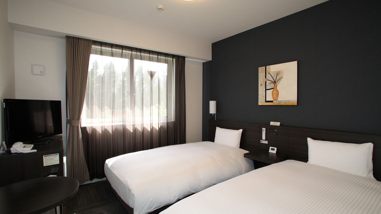 A hotel room with two beds, a desk, a television, and a painting on the wall.