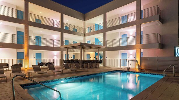 A multi-level hotel with a swimming pool, outdoor seating, and balconies. - Sea Glass Beach Place, Trademark Collection by Wyndham (Lauderdale-by-the-Sea)