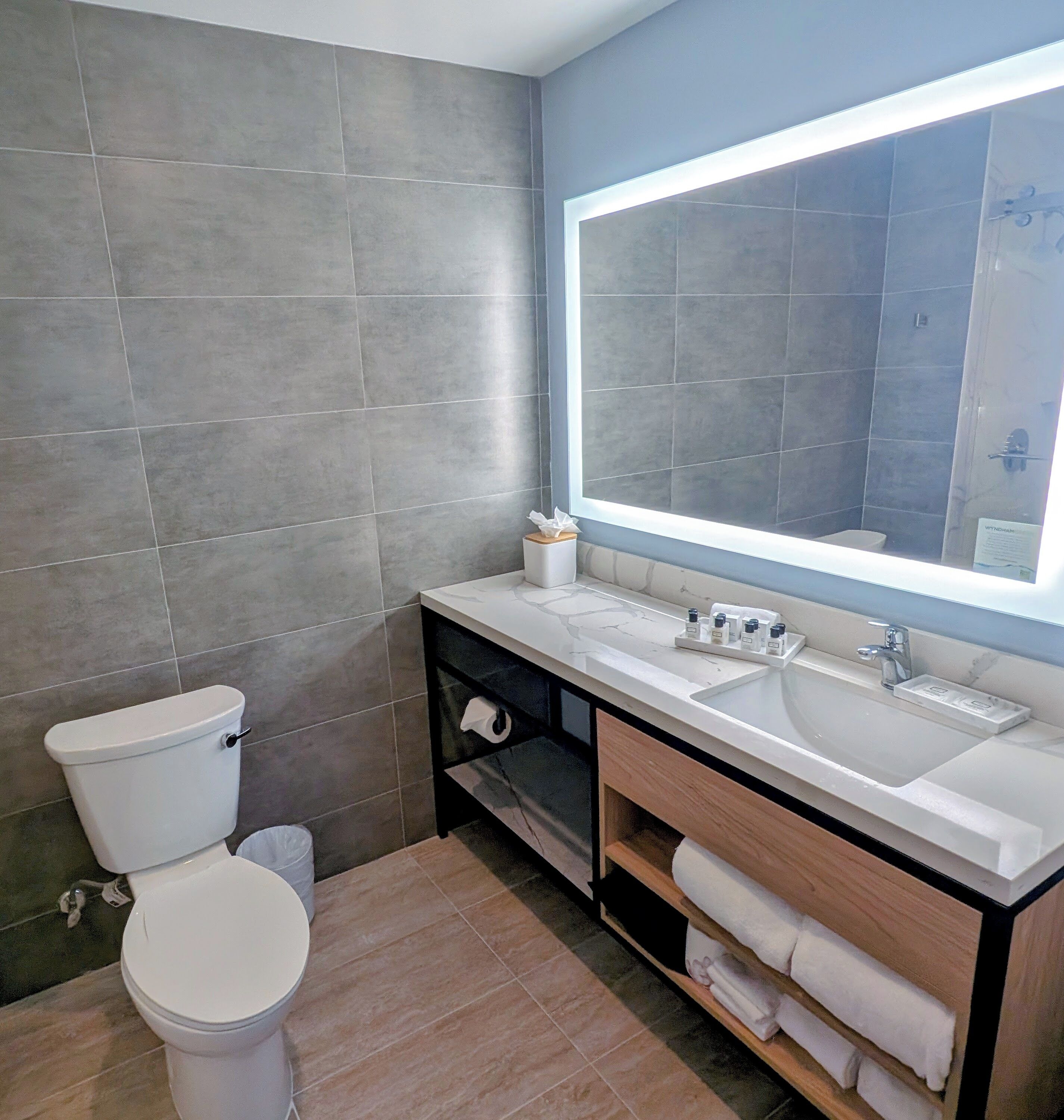 Een moderne badkamer met toilet, wastafel en badmeubel.