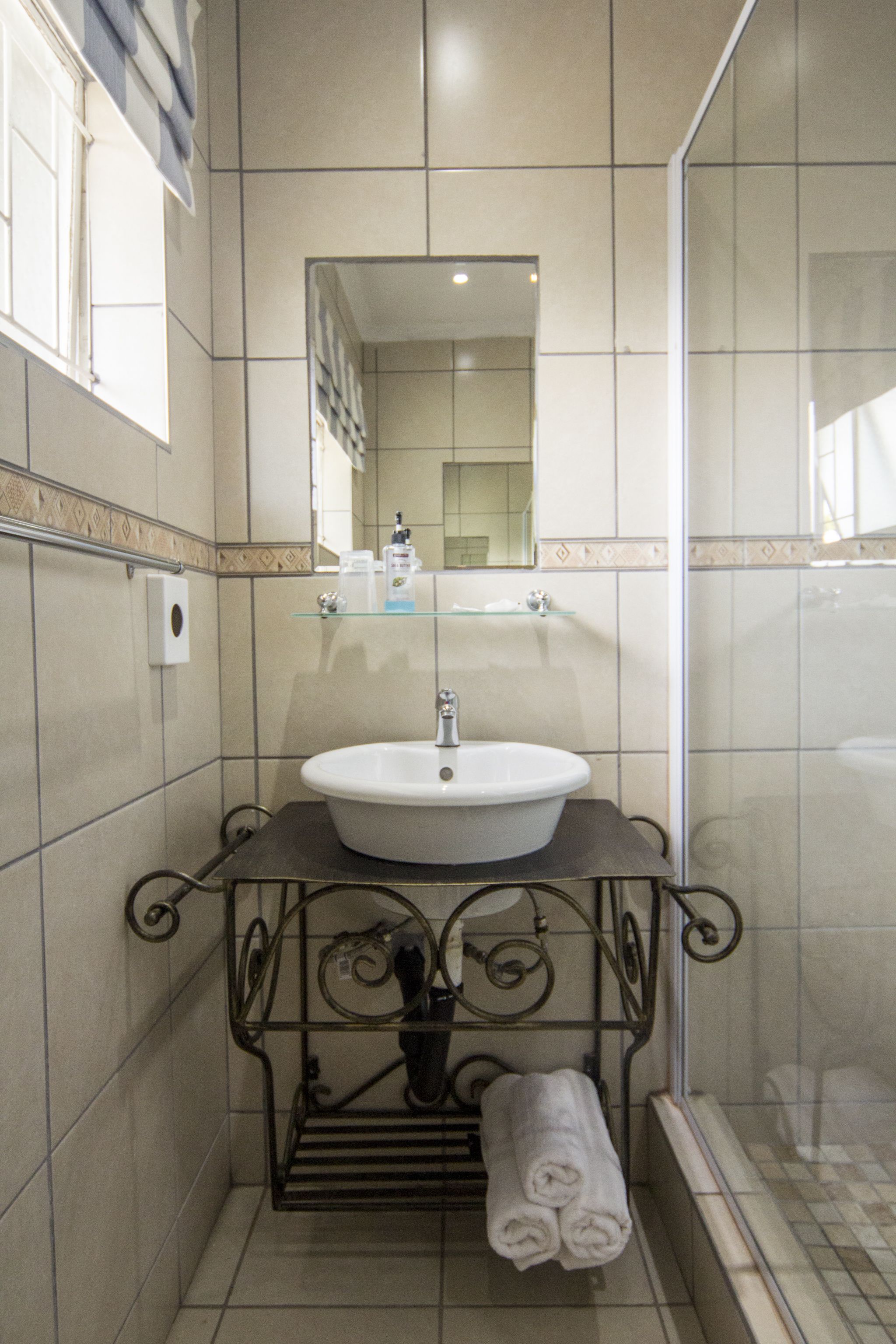 Ein Badezimmer mit Waschbecken, Spiegel und Handtuchhalter.
