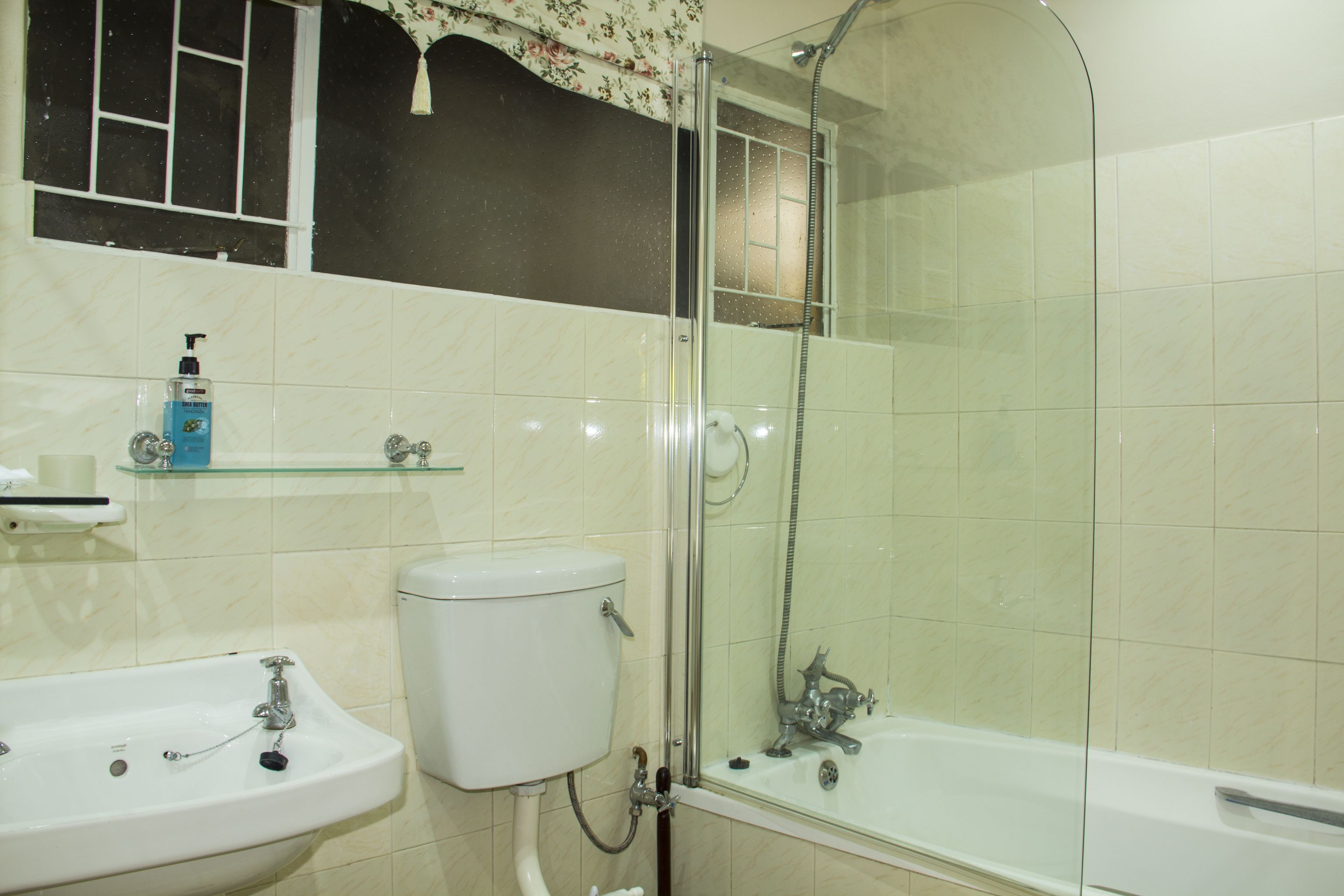 A bathroom with a glass-enclosed shower, a sink, and a toilet.