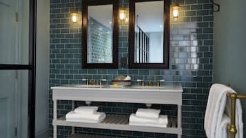A bathroom with a white vanity, two mirrors, and a tiled floor.