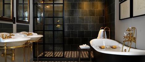 A bathroom with two sinks, a bathtub, and a shower area.