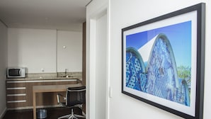 Una cocina moderna con microondas, un lavamanos y una zona de comedor con una silla.