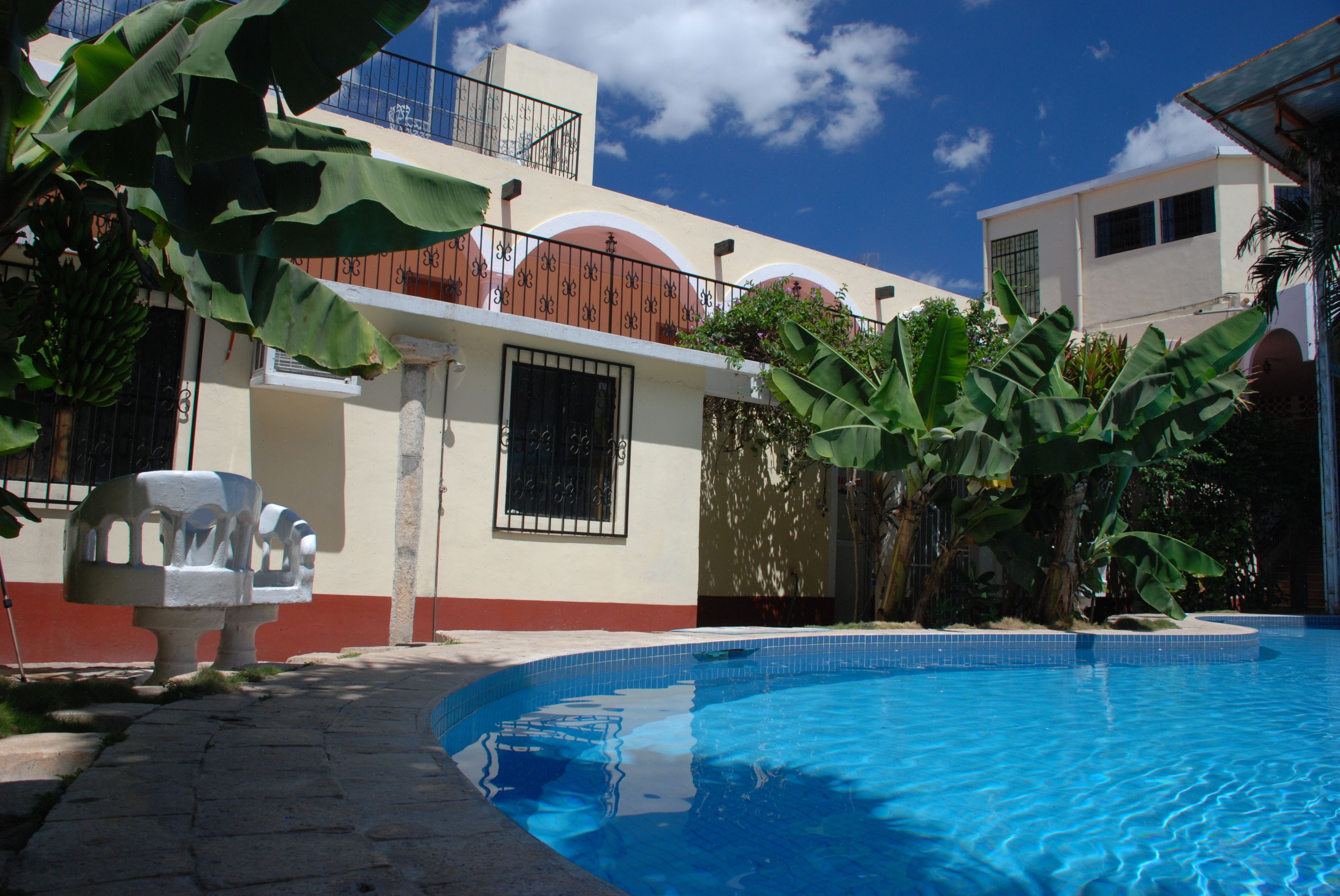 A swimming pool with a tiled edge, surrounded by a paved walkway.