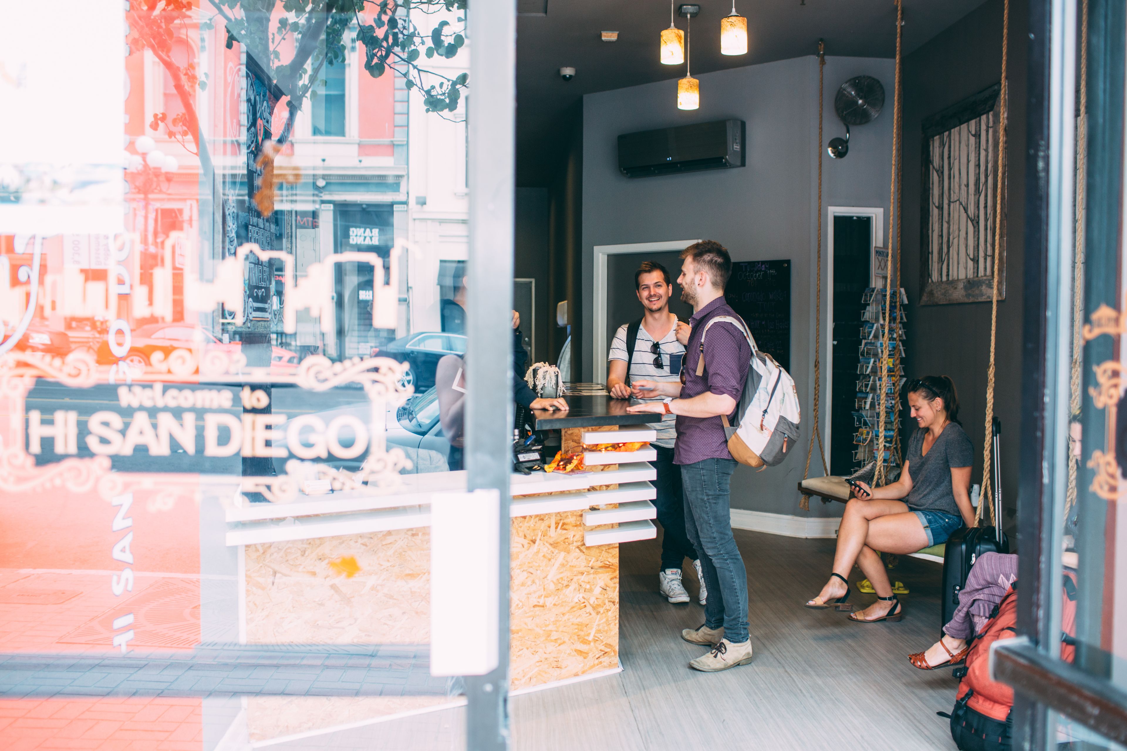A reception area with a counter, a hanging swing, and a view of the street outside.