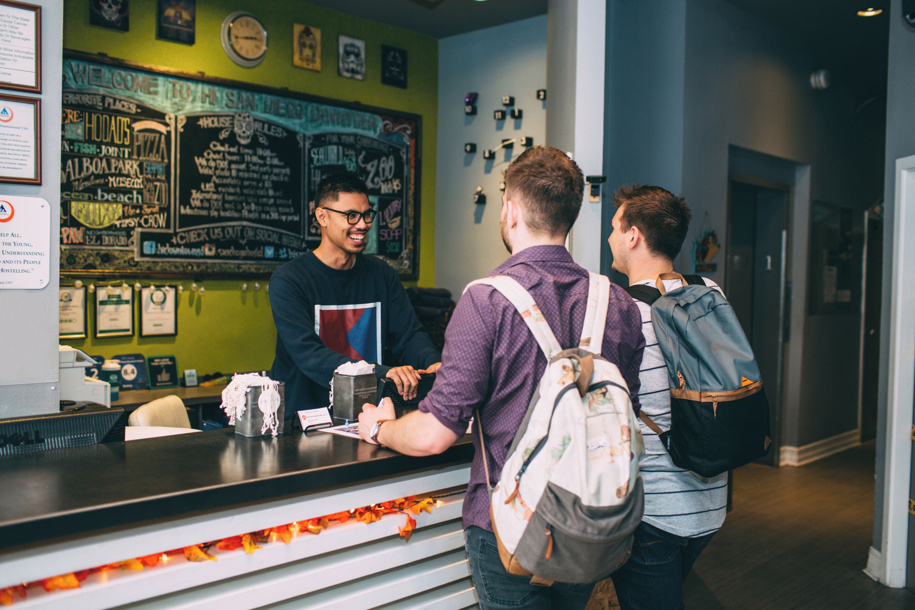 A reception area with a chalkboard menu, a counter, and a wall with various signs and decorations.