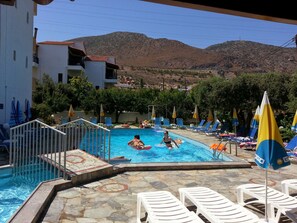 室外游泳池，池畔遮阳伞，日光浴躺椅