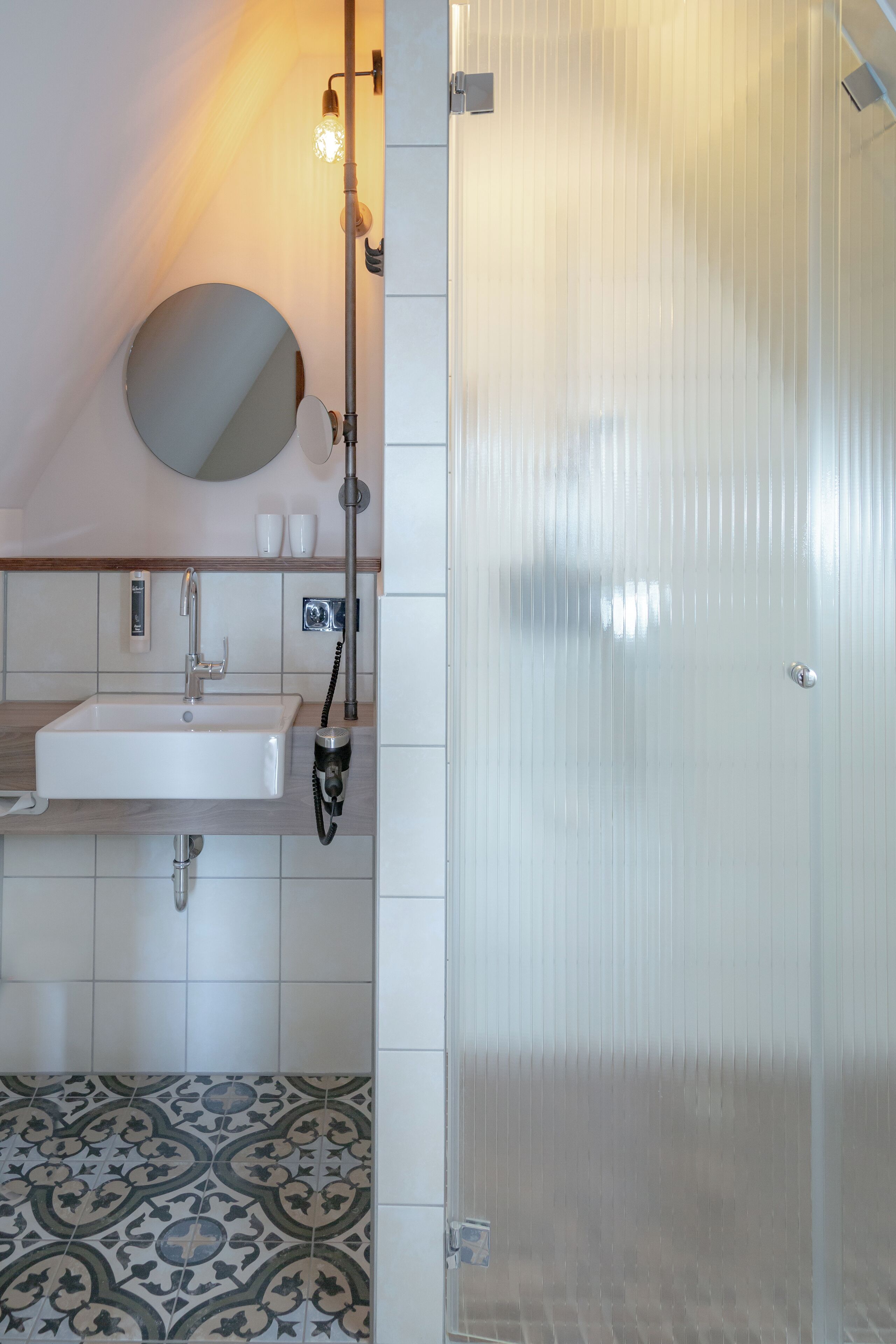 A bathroom with a sink, mirror, and towel rack.