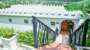 A white building with a central entrance and a staircase leading up to it.