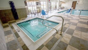 A hotel pool area with a checkered floor, a lifeguard stand, and lounge chairs.