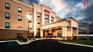 A hotel with a brick facade, a large entrance, and an American flag.