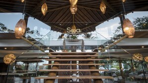 Un spa moderne doté d’un escalier en verre, de poutres en bois et de luminaires suspendus.