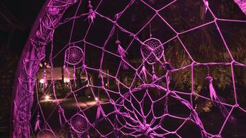Una estructura grande y abovedada con una intrincada red de líneas y nodos interconectados, iluminada con luz púrpura.