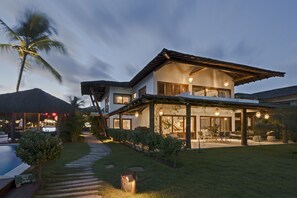 Une maison moderne dotée d’un grand patio, d’une piscine et d’un jardin bien entretenu.