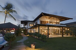 Una casa moderna con un patio amplio, piscina y un jardín bien cuidado.