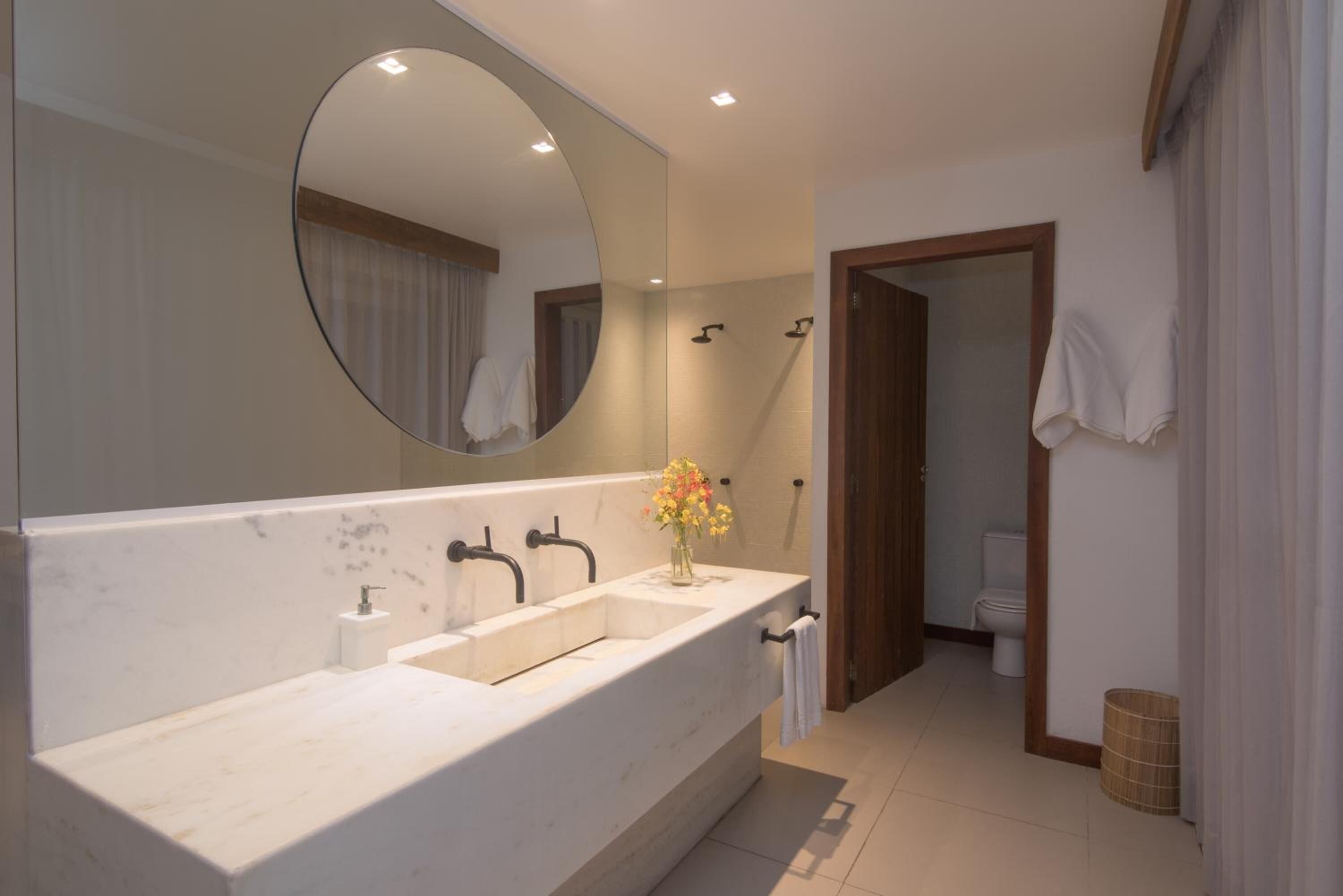 A modern bathroom with a large sink, a mirror, and a shower.