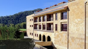 Un edificio de varios pisos con fachada de piedra, balcones y ventanas de arco.