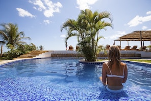 Una piscina al aire libre, sillones reclinables de piscina