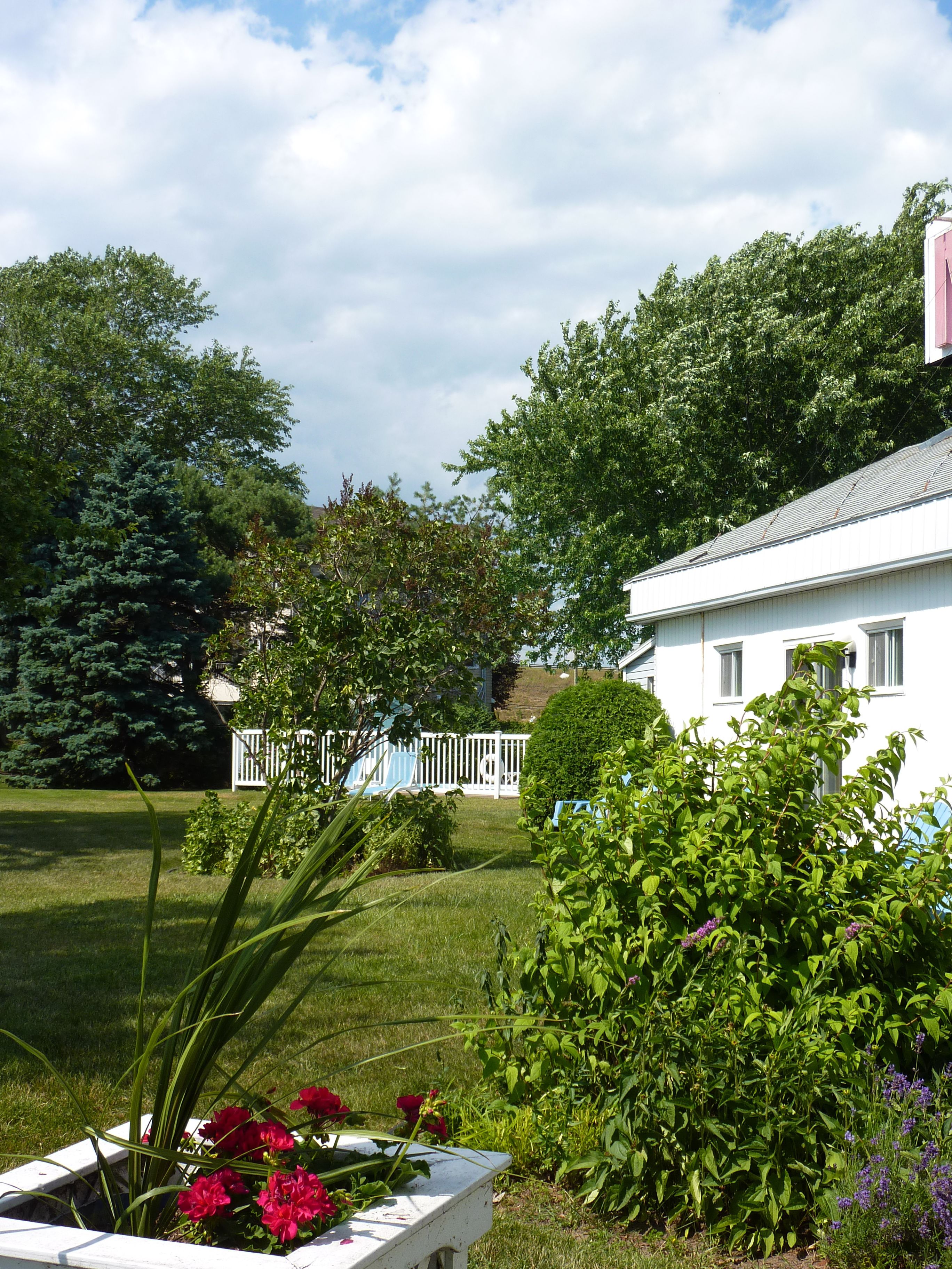 Een wit huis met een witte omheining en een gazon.