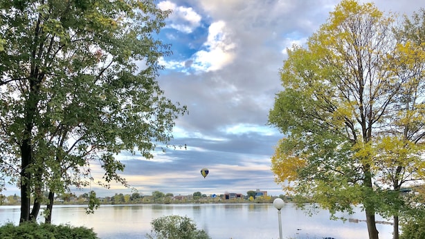 Un parc au bord du lac, avec des chaises et un lampadaire.