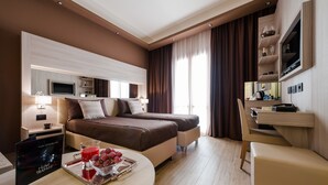 Een hotelkamer met een bed, nachtkastjes, een bureau en een televisie.