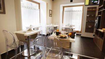 Un espace repas moderne avec des chaises transparentes, une table en bois et une disposition adaptée au petit-déjeuner.