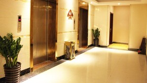 A hotel lobby with elevators, a digital display, and potted plants. - GreenTree Inn Yulin Jincheng Commercial Building Shell Hotel (Yulin)