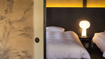 A traditional Japanese room with tatami flooring, a shoji screen, and a futon bed.