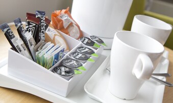Una bandeja con cápsulas de café y una taza blanca.