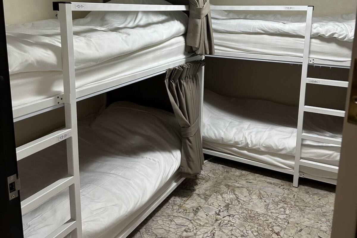 A bunk bed room with a marble floor and a ceiling light.