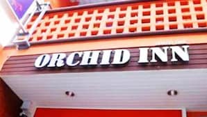El exterior del Orchid Inn, con un letrero llamativo.