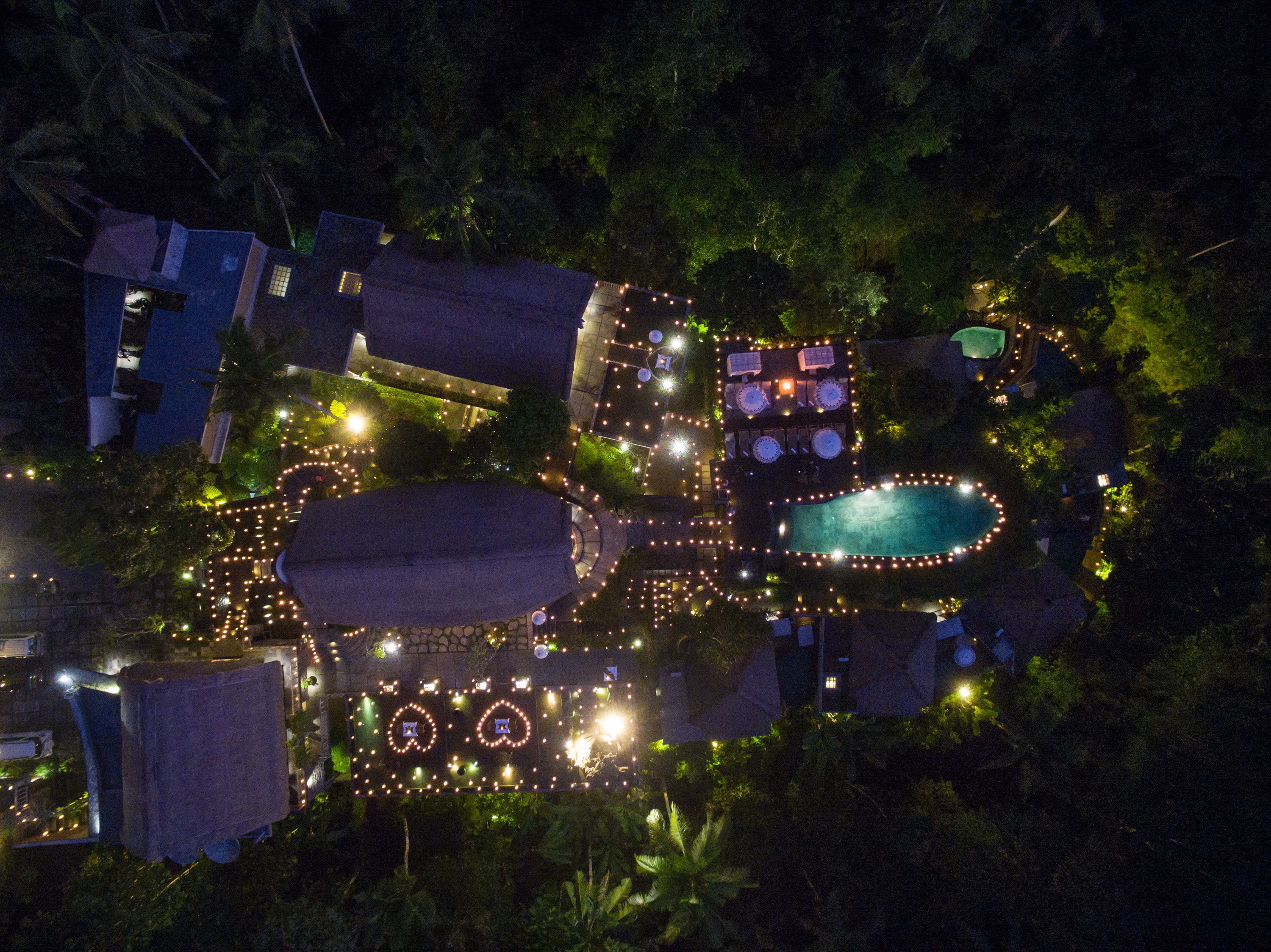 Vista aérea de un resort con múltiples piscinas, una piscina central grande y zonas de estar al aire libre circundantes.