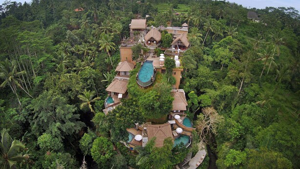 A tropical resort with multiple thatched-roof buildings, swimming pools, and lush greenery. - The Kayon Resort (Ubud)