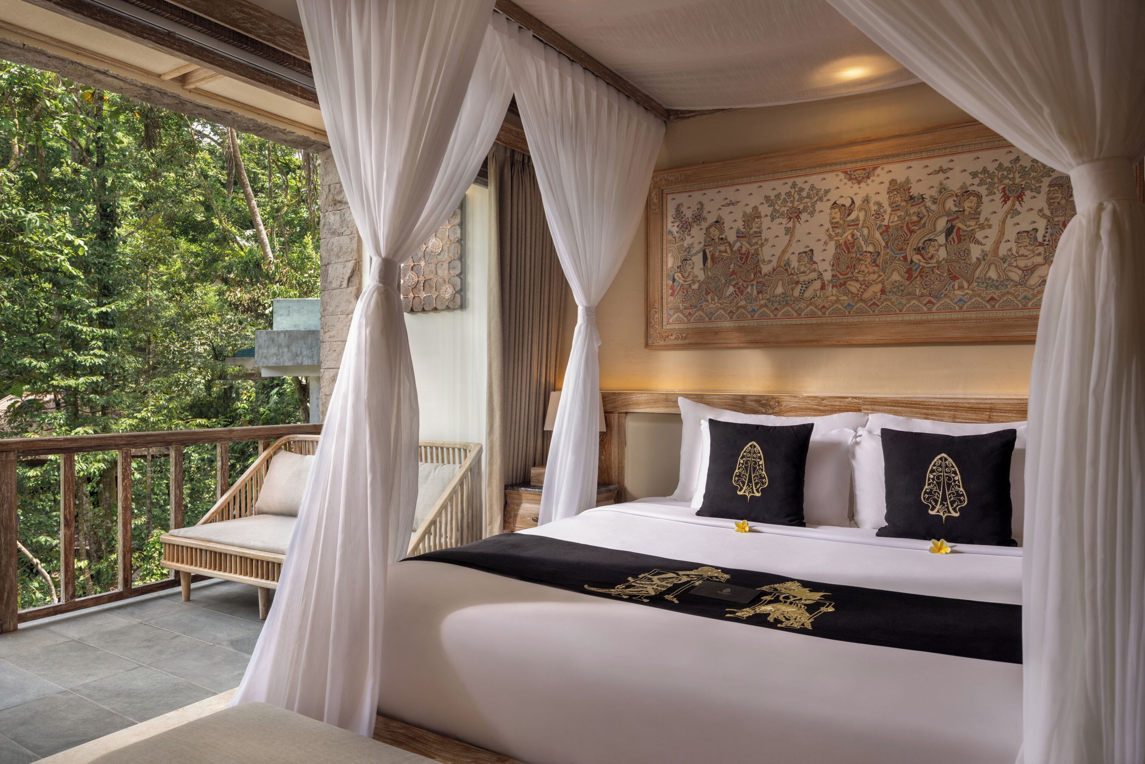 A bedroom with a bed, white curtains, a balcony, and a mural on the wall.